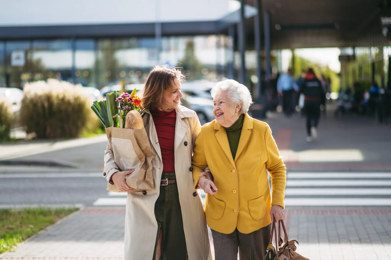 Pflegekraft begleitet eine Seniorin im Alltag